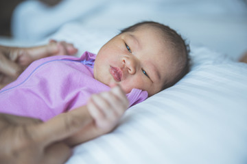newborn baby curled up sleeping on a blanket, holding finger, cl