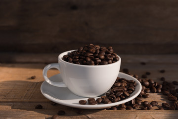 Still life coffee cup and roasted beans on old wood background