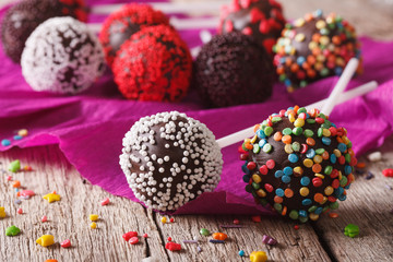 Festive chocolate cake pops with candy sprinkles close-up. horizontal
