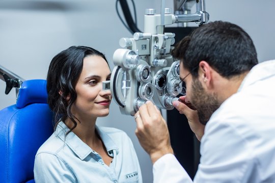 Optician using a phoropter on his patient