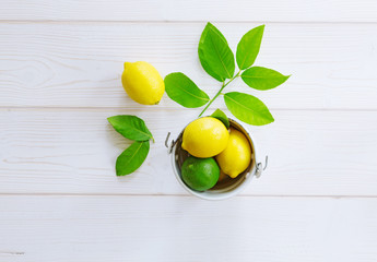 lemon yellow, lime green in a bucket on a light background of boards and leaves