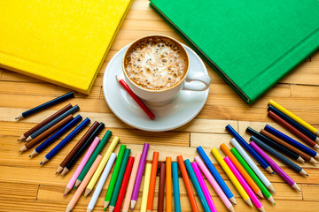 Colorful pencils with books and coffee