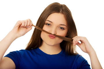 Teenager making moustache from hair.