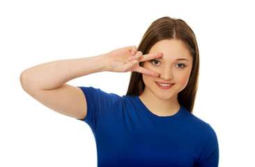 Happy teenager with victory sign on eye.