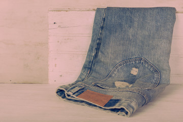 Obraz na płótnie Canvas Blue jeans with leather label on white wood background with retr