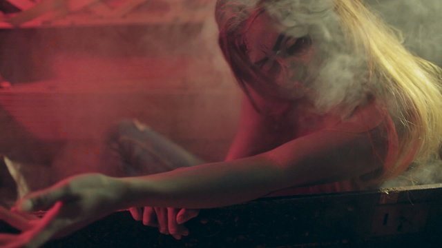 Terrible zombie crawls out of the grave in the smoke