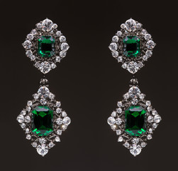 earrings with green stones on the black 