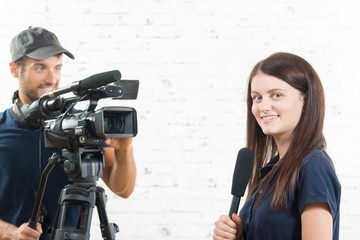 a young journalist with a microphone and a cameraman