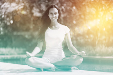 Pretty Smiling Young Woman in Lotus Yoga Pose