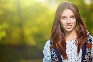 Beautiful woman standing in a park in autumn