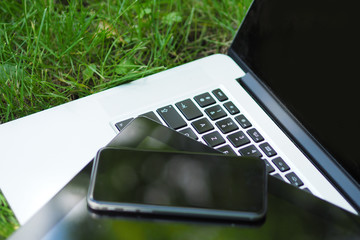 smartphone tablette et ordinateur portable dans l'herbe