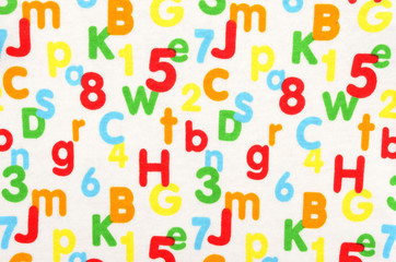 Numbers and letters on white fabric. Colorful pattern with numbers and letters as background.
