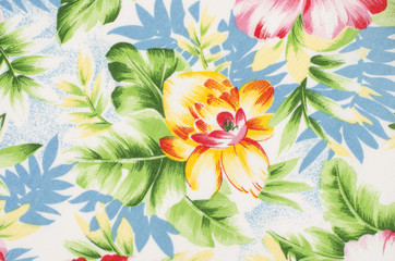 Fototapeta premium Floral pattern on fabric. Yellow and pink big flower with green and blue leaves print as background.
