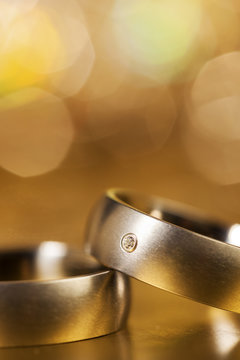 Wedding Rings with golden bokeh background, closeup