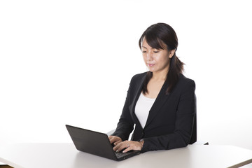 ノートパソコンで仕事をする日本人のビジネスウーマン