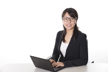 ノートパソコンで仕事をする日本人のビジネスウーマン