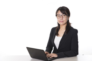 ノートパソコンで仕事をする日本人のビジネスウーマン