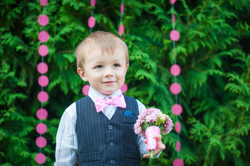 Beautiful little boy with a bouquet of flowers