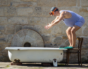man in retro swimsuit jumps to the outdoor bathtub