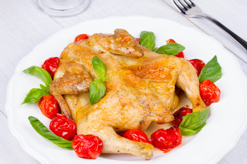 Whole roast chicken with tomatoes cherry, green basil and garlic