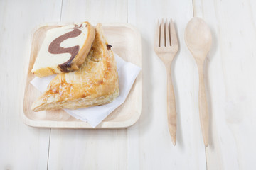 Pie and wooden fork and spoon on wooden background