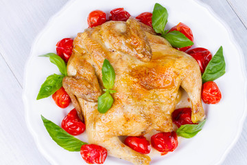 Whole roast chicken with tomatoes cherry, green basil and garlic