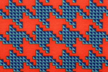 Orange and blue houndstooth pattern. Closeup on big dogstooth check design as background.