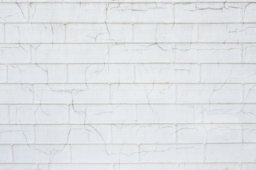 White brick wall with cracks