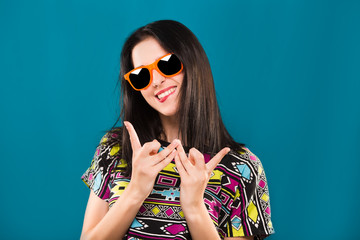 Happy woman having fun on the blue background, in studio