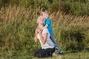 Young woman hug her son on the nature