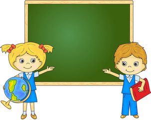 Boy and girl standing near the blackboard in a classroom
