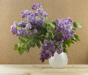 Lilac bouquet in a white glass vase