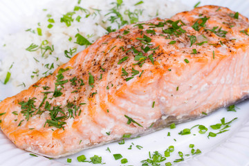 Steamed salmon with fresh herbs and lemon. Rice as a garnish