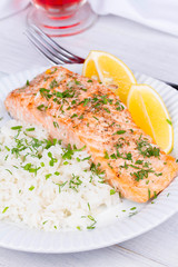 Steamed salmon with fresh herbs and lemon. Rice as a garnish