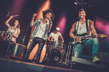 Naklejka premium Multiracial music band performing on a stage