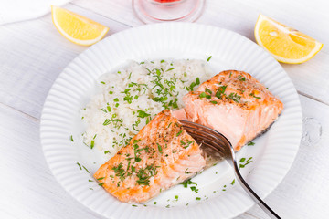 Steamed salmon with fresh herbs and lemon. Rice as a garnish