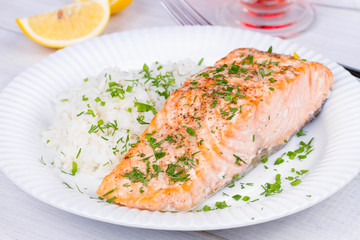 Steamed salmon with fresh herbs and lemon. Rice as a garnish