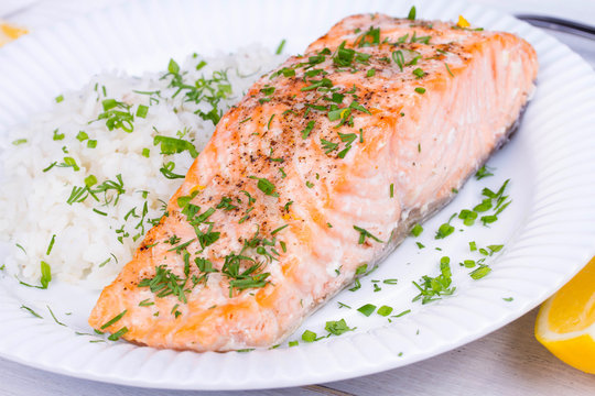 Steamed salmon with fresh herbs and lemon. Rice as a garnish