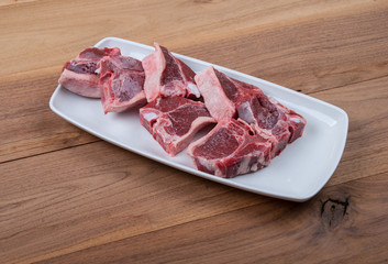 Raw lamb chops with spices and herbs on wooden background