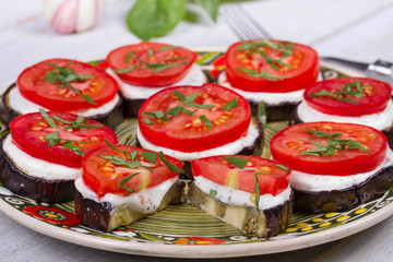Grilled eggplant with spicy sour cream sauce, tomatoes and basil