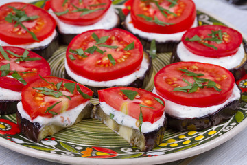 Grilled eggplant with spicy sour cream sauce, tomatoes and basil