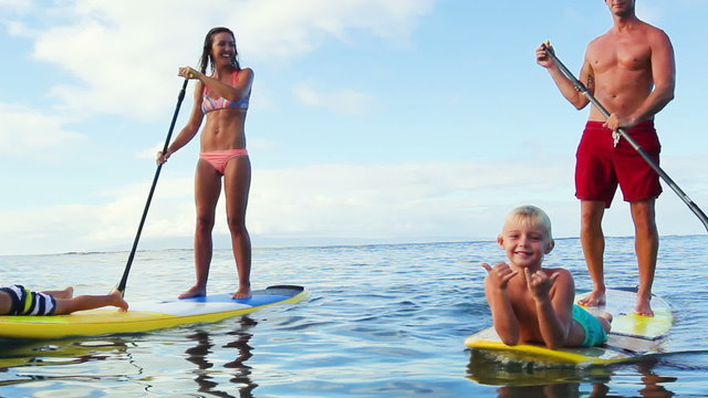 Family Stand Up Paddling on Sunny Blue Sky Morning Sunrise in Hawaii. Summer Fun Family Vacation Healthy Lifestyle. Learning to Surf. SUP.