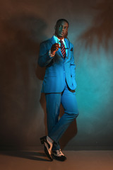 Retro african american businessman in blue suit holding sunglass