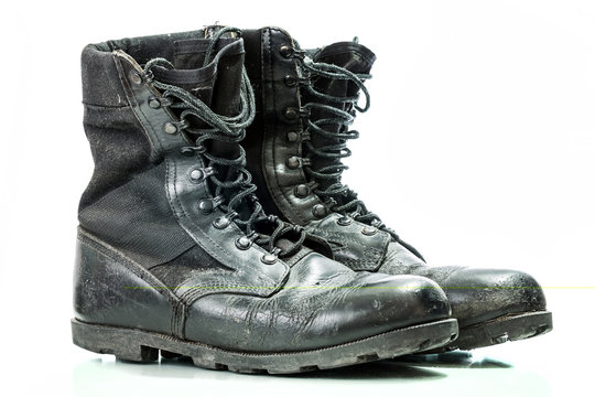 Black old combat military boots isolated on white background