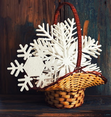Snowflakes from polyfoam in a basket on wooden texture