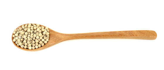 White pepper in wooden spoon on a white background