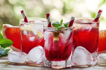 Red cocktail with grapefruit and ice in the shape of a heart on