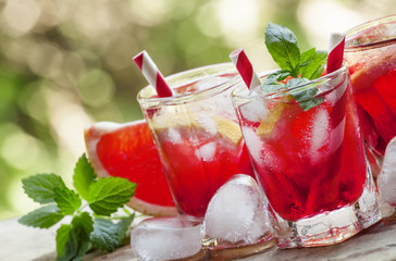 Red cocktail with grapefruit and ice in the shape of a heart on