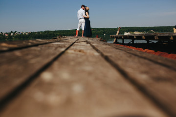 Hugging man and woman in love on wooden pier