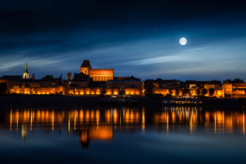 Old town reflected in river at sunset. Torun, Poland. - obrazy, fototapety, plakaty